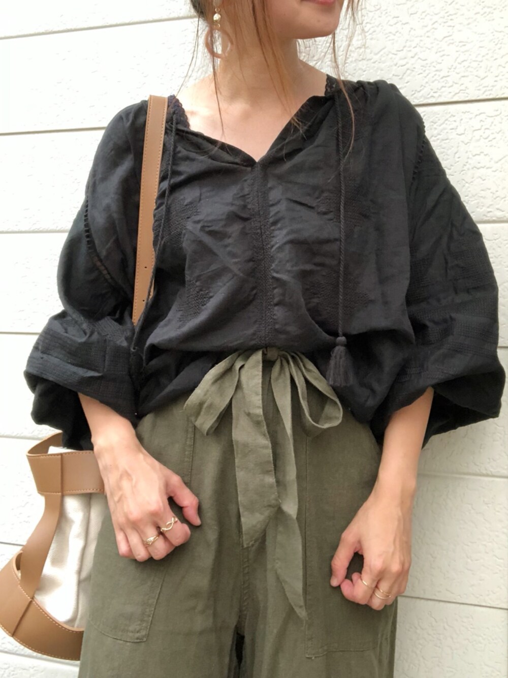 ブラック系のシャツ/ブラウス、グリーン系のその他パンツ、ベージュ系のイヤリングを着用したレディースの夏コーディネートの1枚目の写真