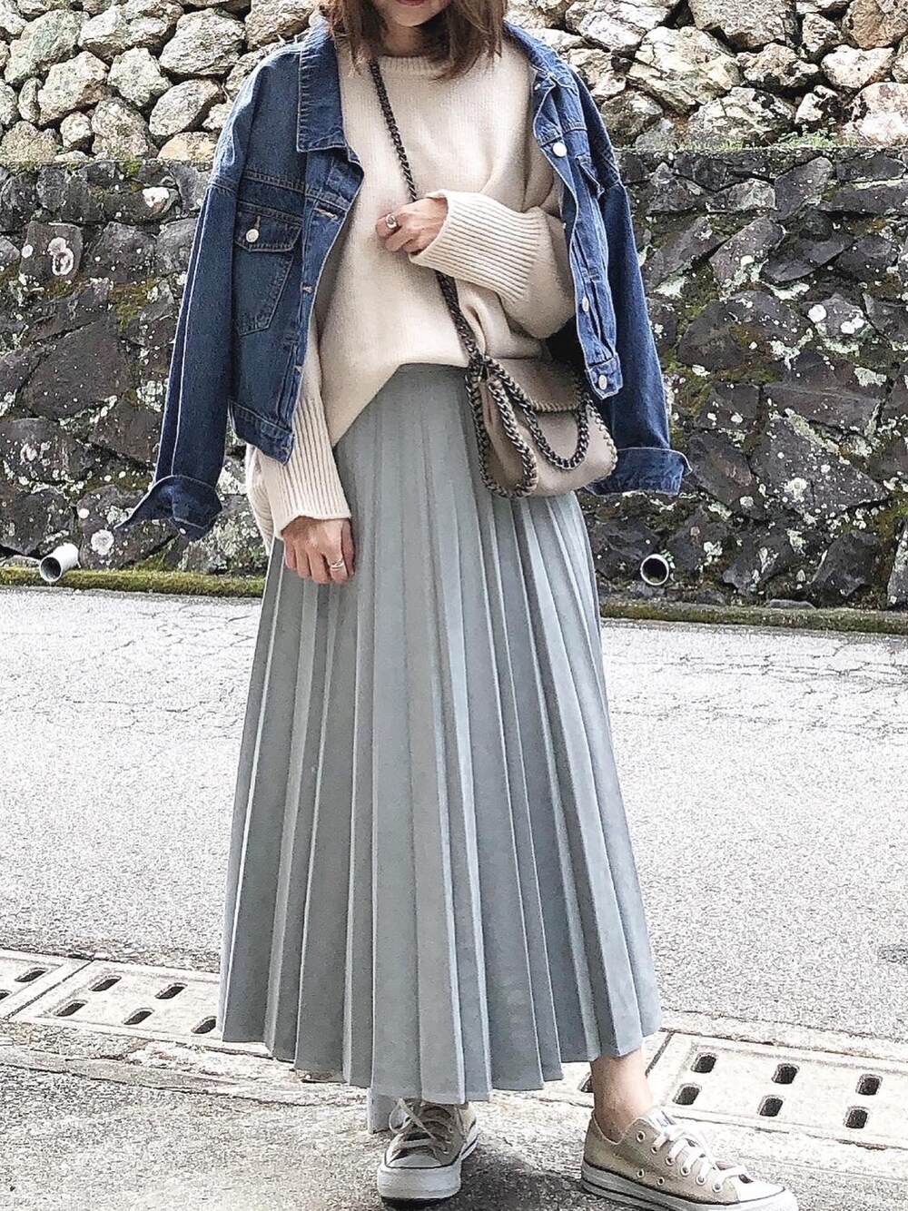 ホワイト系のニット/セーター、ベージュ系のショルダーバッグ、ブルー系のデニムジャケットを着用したレディースの冬コーディネートの1枚目の写真