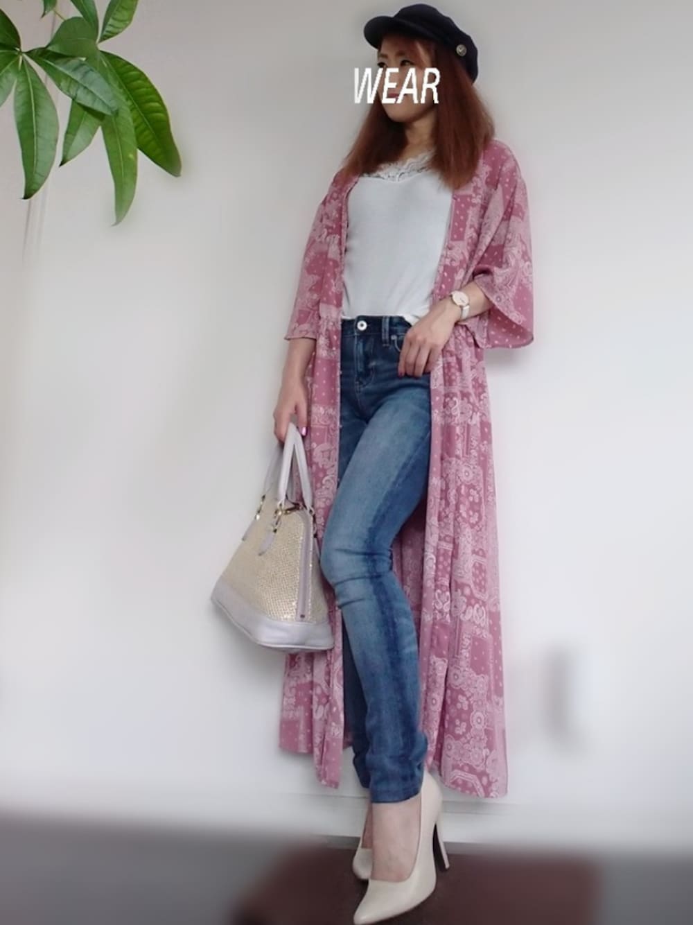 ピンク系のシャツワンピース、ベージュ系のハンドバッグ、ブルー系のデニムパンツを着用したレディースの夏コーディネートの1枚目の写真