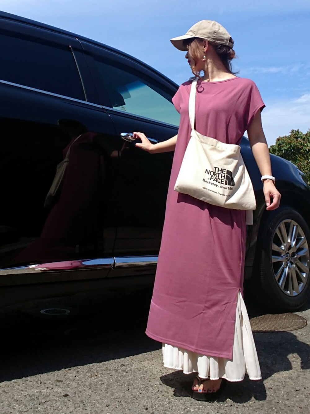 ブラック系のショルダーバッグ、ホワイト系のスカート、ベージュ系のキャップを着用したレディースの夏コーディネートの1枚目の写真