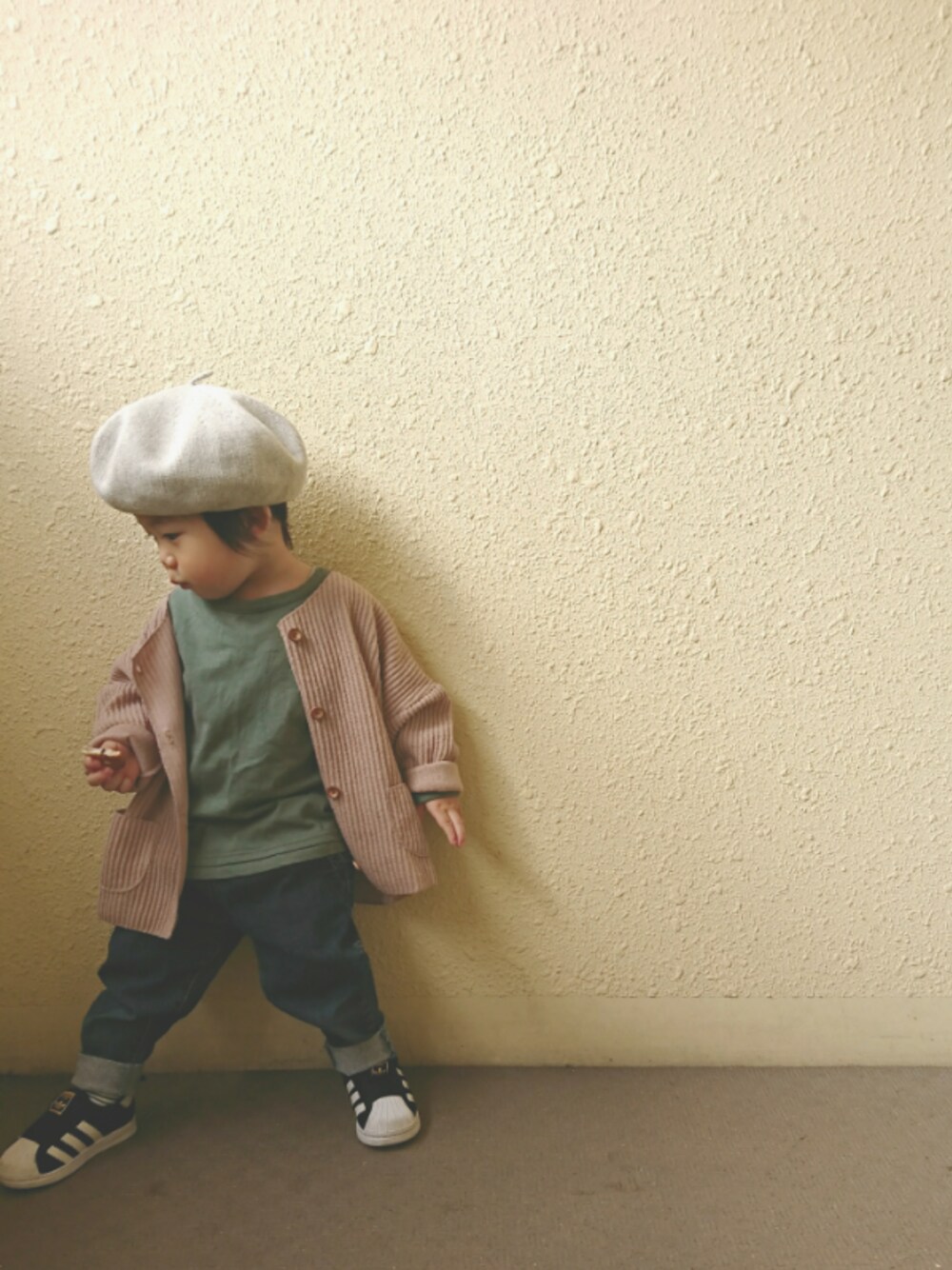 ベージュ系のカーディガン/ボレロ、ブラック系のスリッポン、グリーン系のTシャツ/カットソーを着用したキッズの秋コーディネートの1枚目の写真