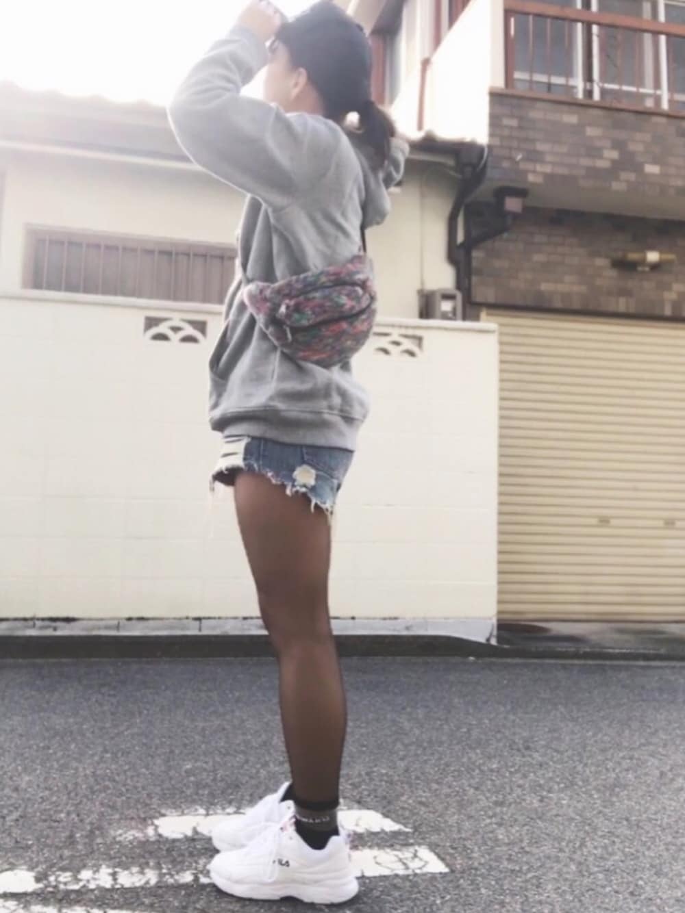 グレー系のパーカー、ブルー系のデニムパンツ、その他のボディバッグ/ウエストポーチを着用したレディースの冬コーディネートの1枚目の写真