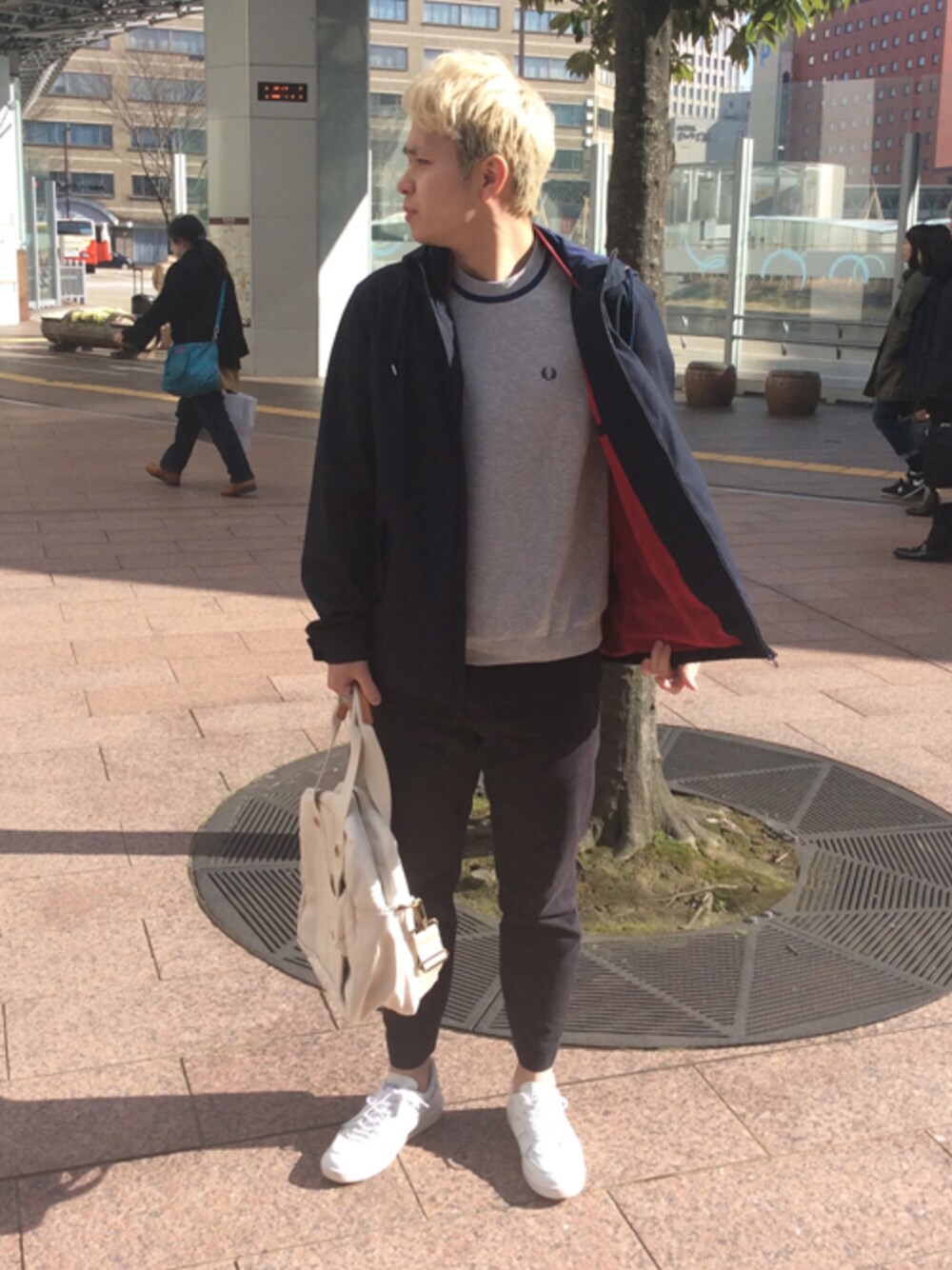 グレー系のニット/セーター、ブルー系のマウンテンパーカー、ホワイト系のボストンバッグを着用したメンズの春コーディネートの1枚目の写真