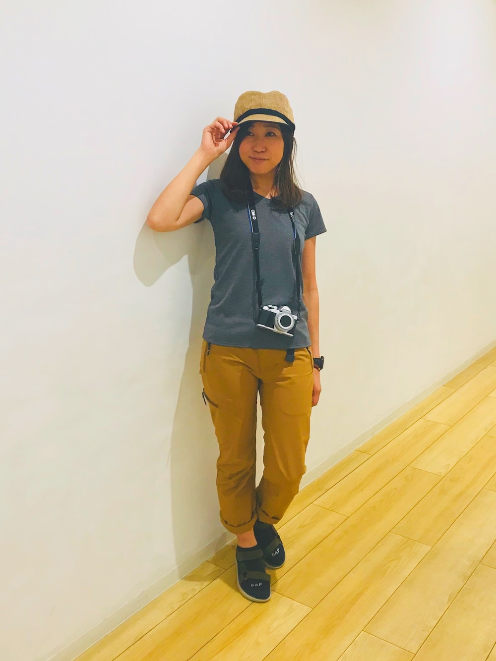 グレー系のTシャツ/カットソー、ブラウン系のパンツ、グリーン系のサンダルを着用したレディースの春コーディネートの1枚目の写真