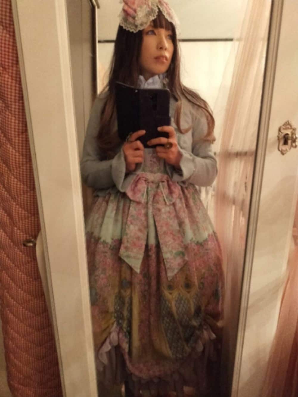 パープル系のシャツ/ブラウス、グリーン系のジャンパースカート、グリーン系のカーディガン/ボレロを着用したレディースの冬コーディネートの1枚目の写真