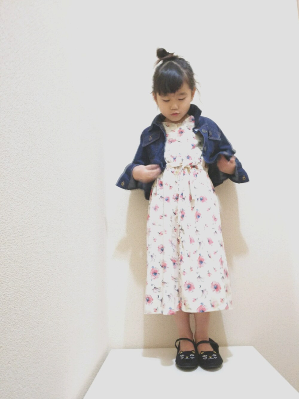 ホワイト系のワンピース、ブルー系のデニムジャケット、ブラック系のバレエシューズを着用したキッズの春コーディネートの1枚目の写真