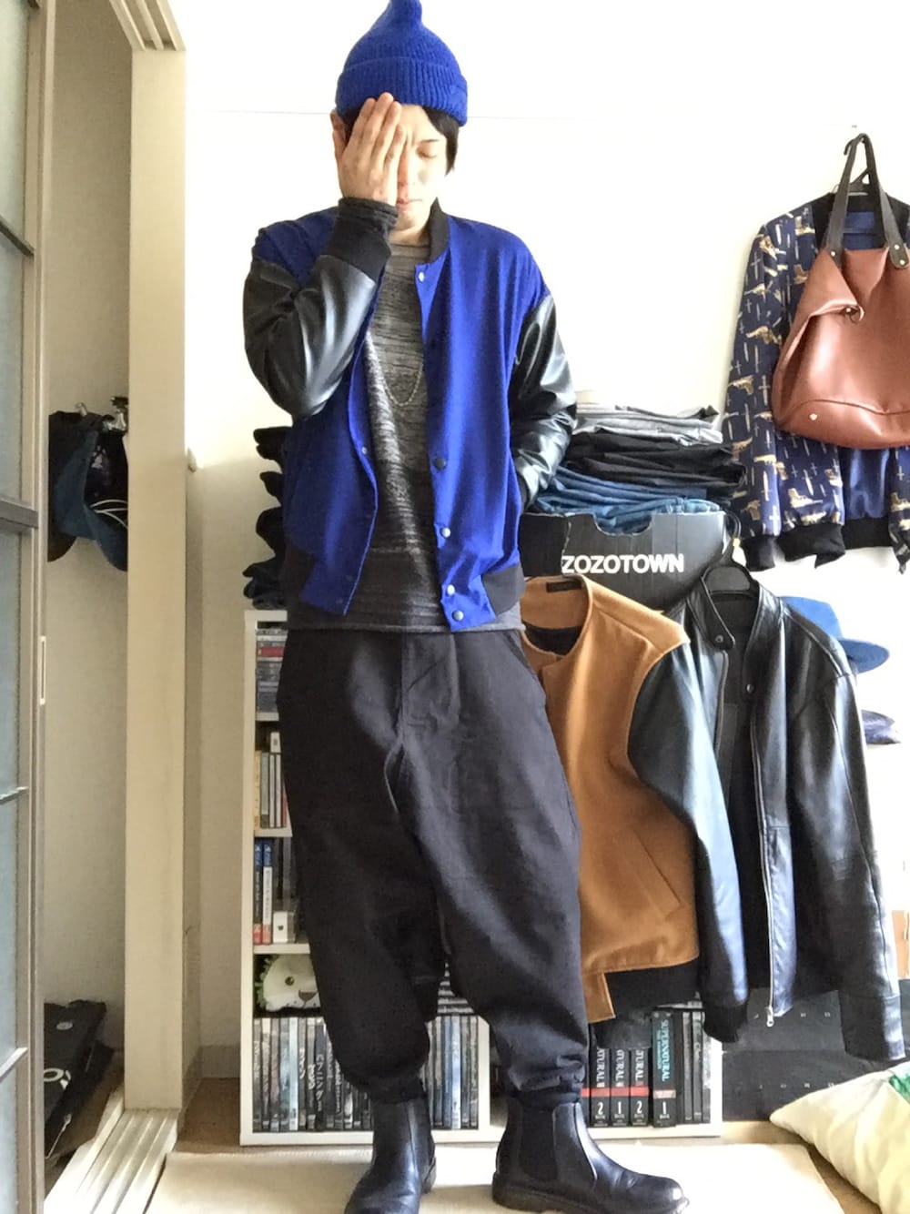 ブルー系のスタジャン、グレー系のニット/セーター、ブラック系のカーゴパンツを着用したメンズの冬コーディネートの1枚目の写真