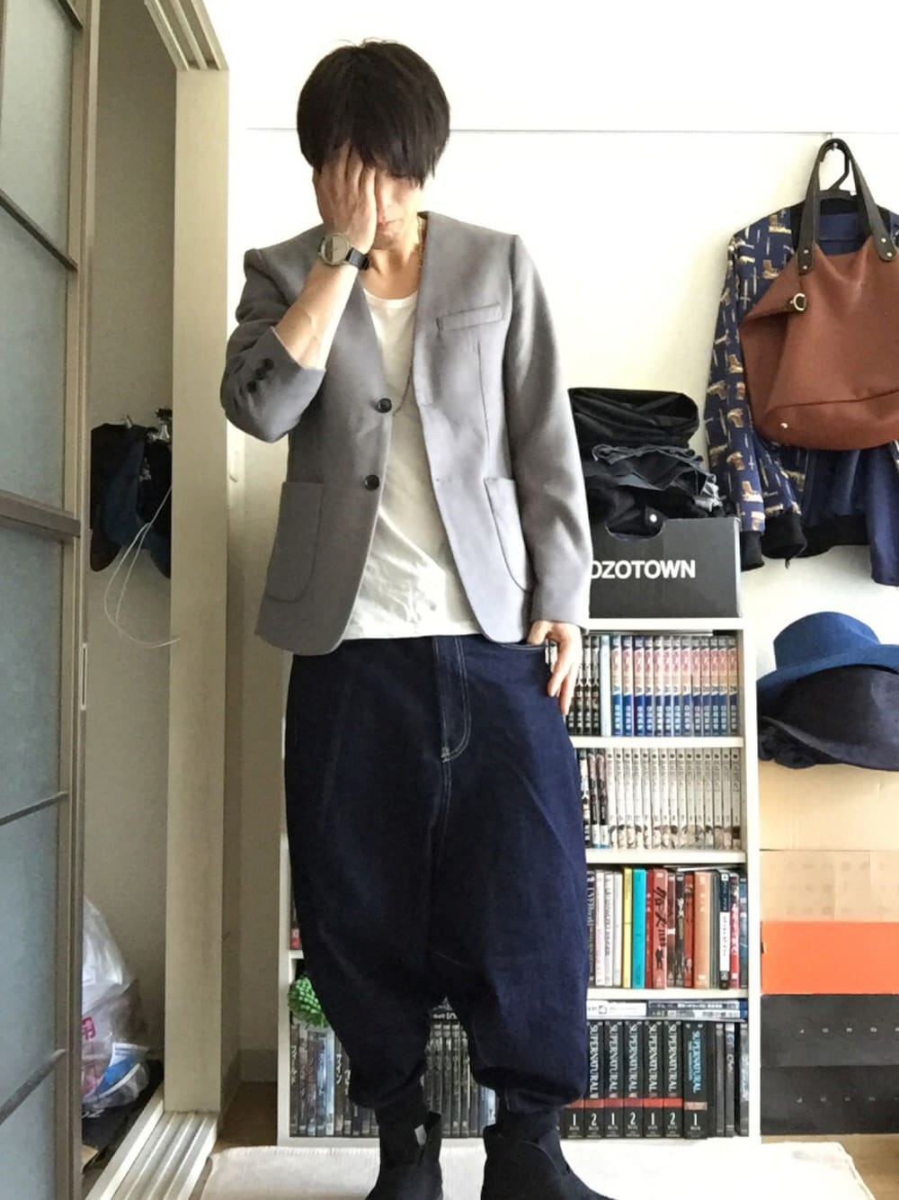 グレー系のテーラードジャケット、グレー系のTシャツ/カットソー、ブルー系のデニムパンツを着用したメンズの秋コーディネートの1枚目の写真