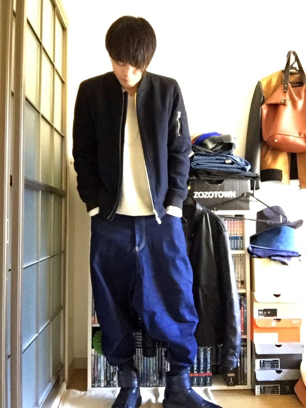 ブルー系のブルゾン、ベージュ系のニット/セーター、ブルー系のデニムパンツを着用したメンズの冬コーディネートの1枚目の写真