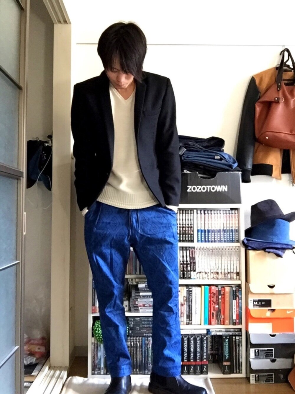 ブラック系のテーラードジャケット、ベージュ系のニット/セーター、ブルー系のその他パンツを着用したメンズの冬コーディネートの1枚目の写真