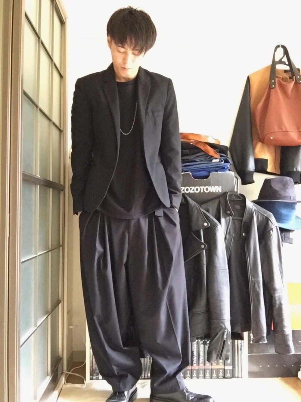 ブラック系のテーラードジャケット、ブラック系のTシャツ/カットソー、ブラック系のスラックスを着用したメンズの秋コーディネートの1枚目の写真