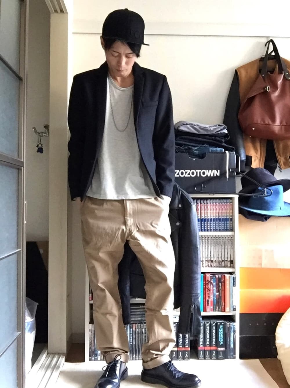 ブラック系のテーラードジャケット、ベージュ系のTシャツ/カットソー、ベージュ系のチノパンツを着用したメンズの冬コーディネートの1枚目の写真