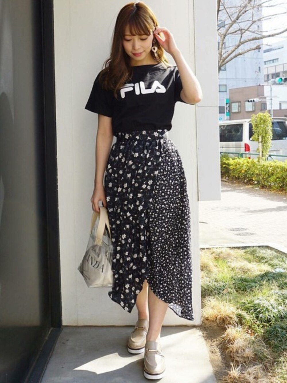 「ブラック、Tシャツ、ローファー、大人カジュアル、FILA、カジュアルミックス、花柄スカート、MERCURYDUO(MERCURYDUO)、クリアバッグ、大人フェミニン」｜「MERCURYDUOの【FILA×MERCURYDUO】ロゴTシャツ（Tシャツ/カットソー、ブラック系）」を使った、児玉亜由美さん（レディース・160cm）の夏コーディネートの1枚目の写真