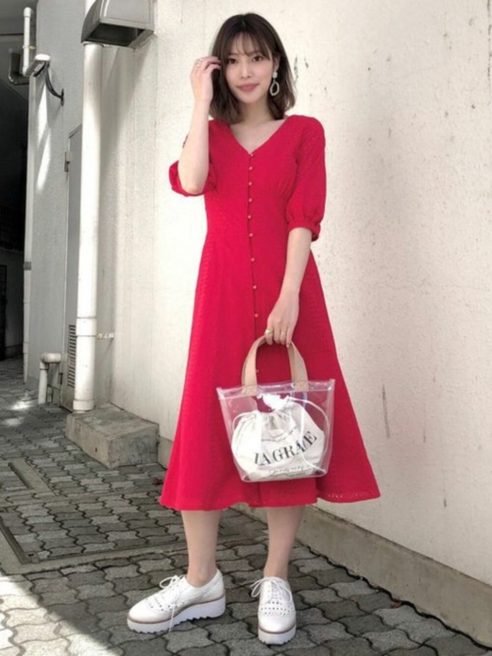 レッド系のシャツワンピース、ベージュ系のトートバッグ、ホワイト系のローファーを着用したレディースの冬コーディネートの1枚目の写真