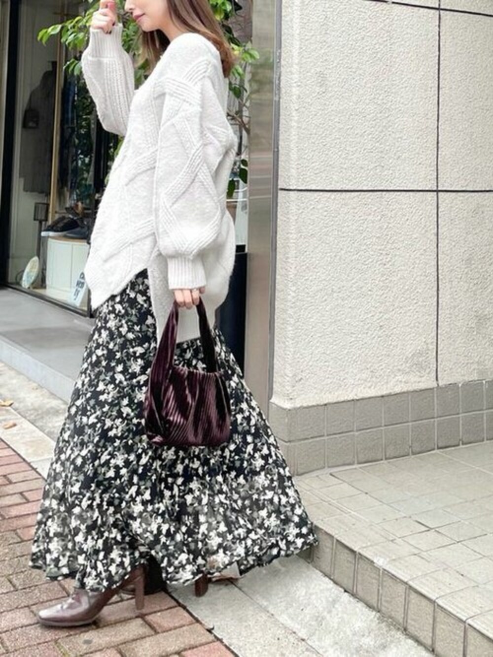 ブラック系のスカート、グレー系のニット/セーターを着用したレディースの冬コーディネートの1枚目の写真