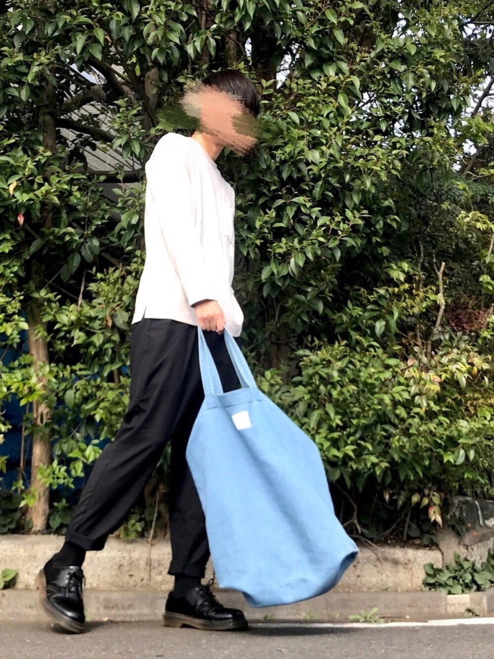 ホワイト系のTシャツ/カットソー、ブラック系のスラックス、ブルー系のトートバッグを着用したメンズの春コーディネートの1枚目の写真