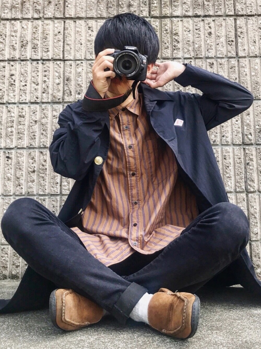 ブラック系のステンカラーコート、ブラウン系のシャツ/ブラウス、ブラック系のデニムパンツを着用したメンズの秋コーディネートの1枚目の写真