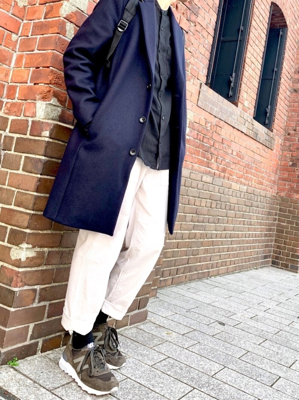ブルー系のチェスターコート、ブラック系のシャツ/ブラウス、ホワイト系のパンツを着用したメンズの秋コーディネートの1枚目の写真