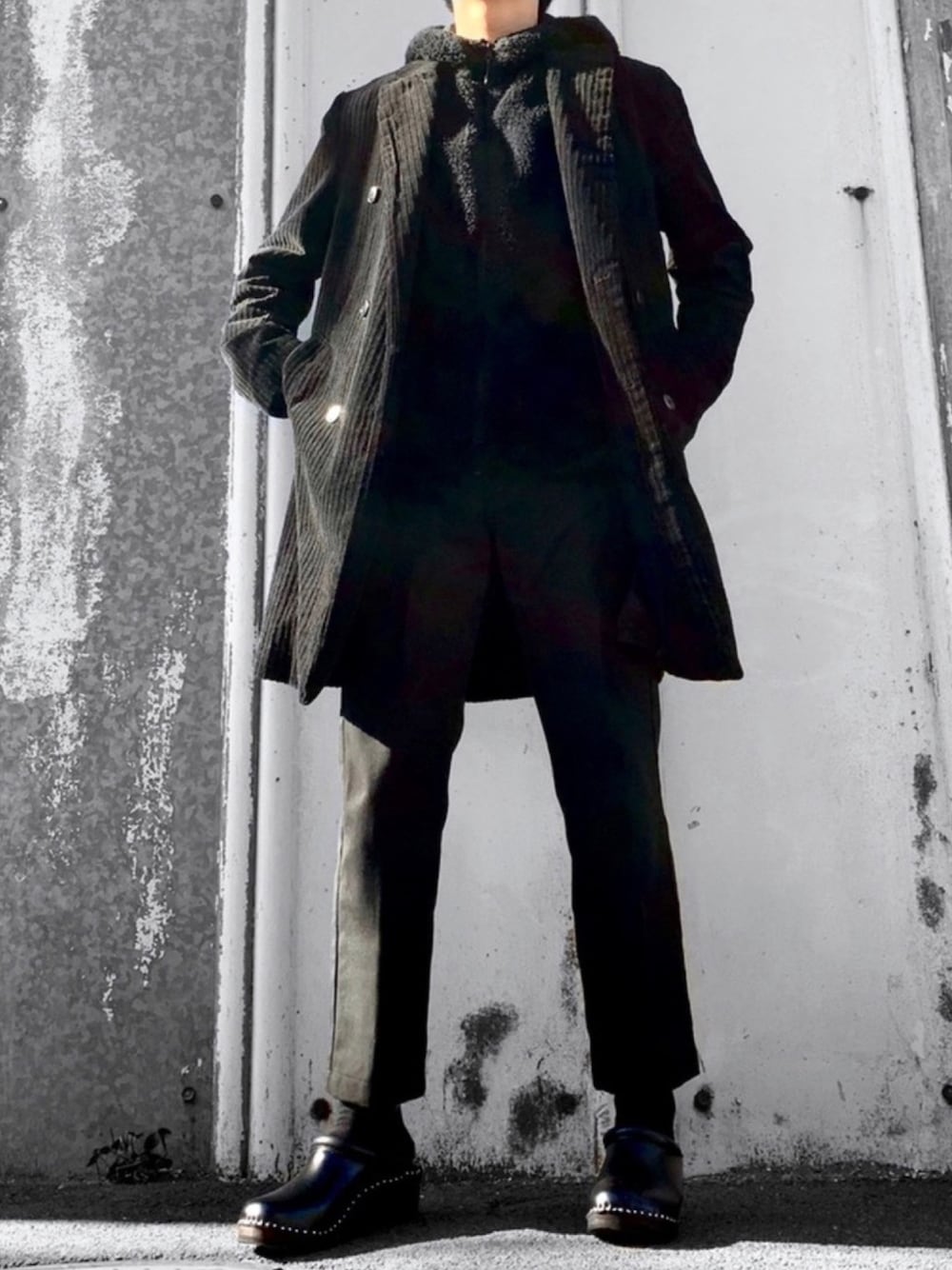 ブラック系のチェスターコート、ブラック系のその他アウター、ブラック系のチノパンツを着用したメンズの冬コーディネートの1枚目の写真