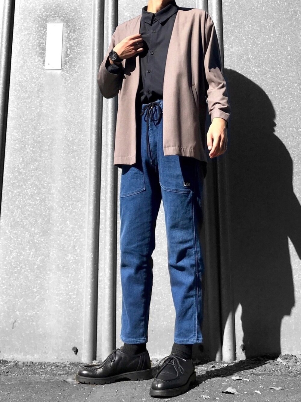 ベージュ系のその他アウター、ブルー系のデニムパンツ、ブラック系のモカシン/デッキシューズを着用したメンズの秋コーディネートの1枚目の写真