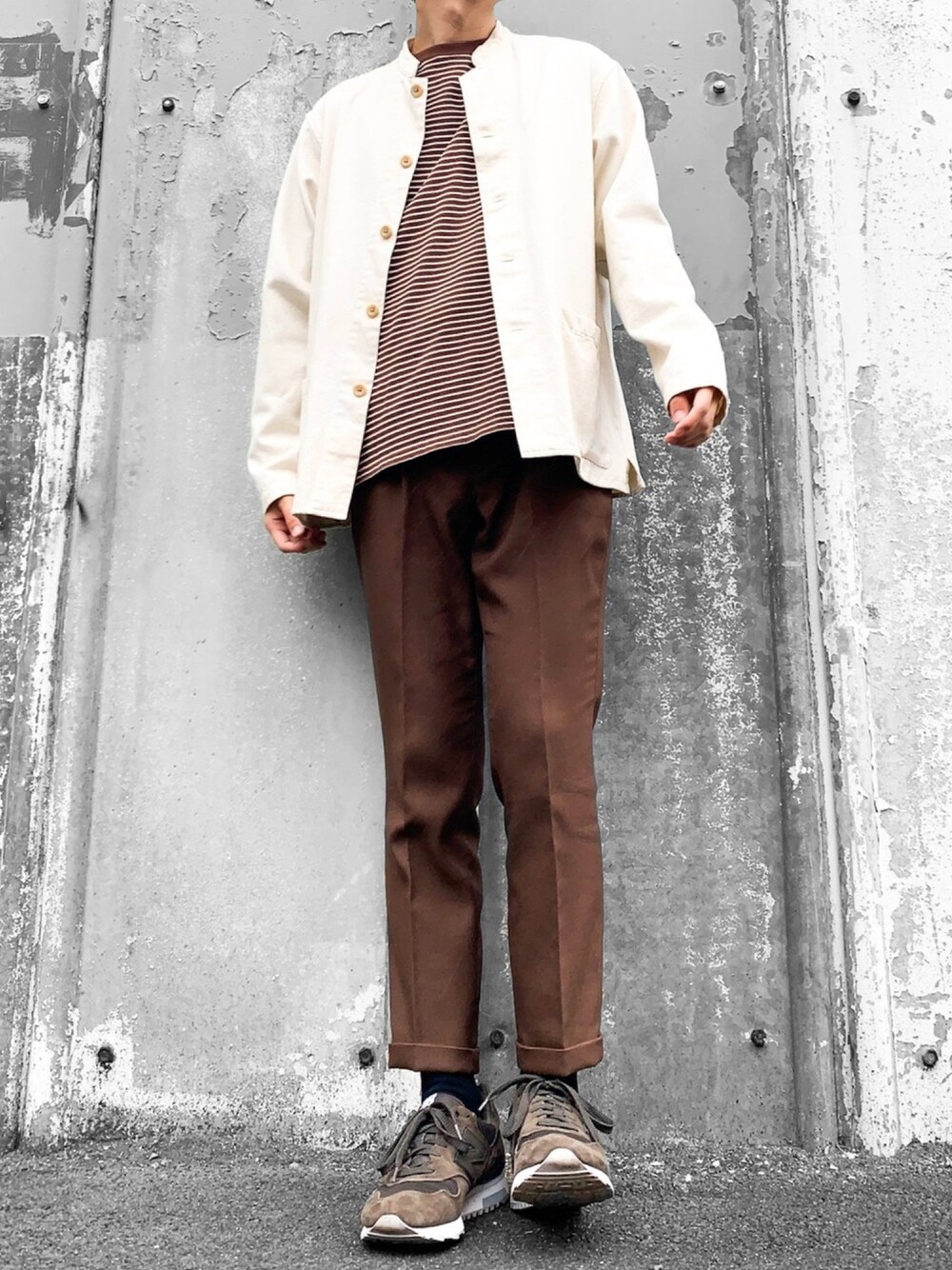 ベージュ系のカバーオール、オレンジ系のTシャツ/カットソー、ブラック系のスニーカーを着用したメンズの秋コーディネートの1枚目の写真