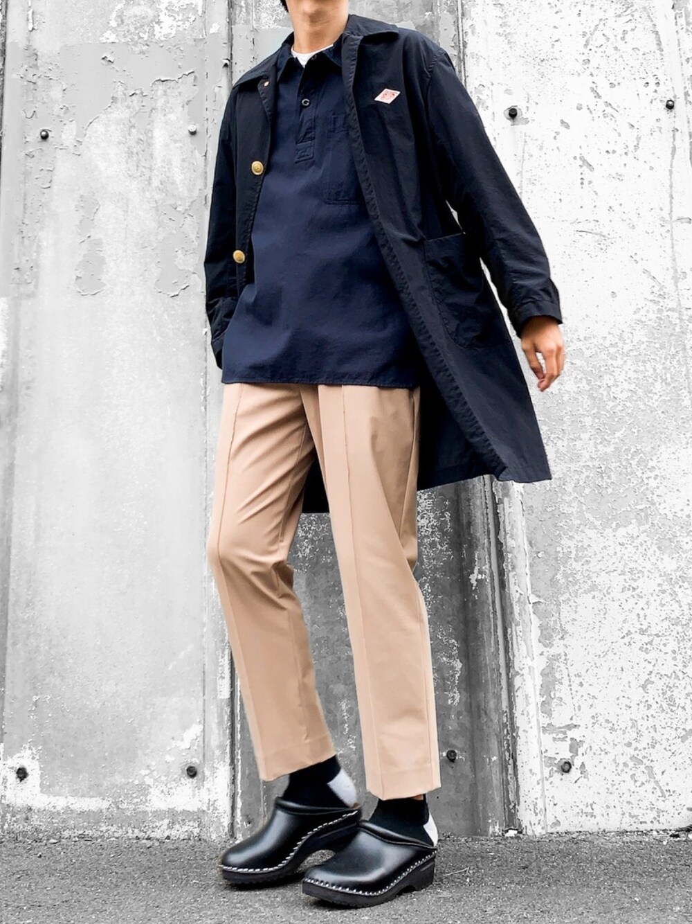 ブラック系のステンカラーコート、ホワイト系のTシャツ/カットソー、ブルー系のシャツ/ブラウスを着用したメンズの秋コーディネートの1枚目の写真