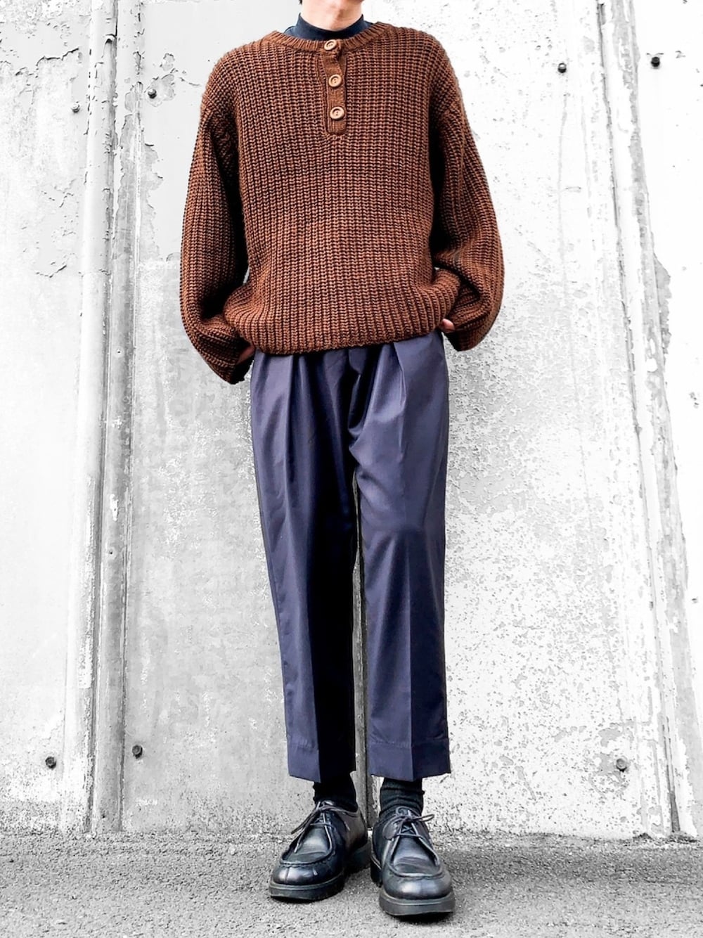 ブラウン系のニット/セーター、グリーン系のTシャツ/カットソー、ブルー系のスラックスを着用したメンズの冬コーディネートの1枚目の写真