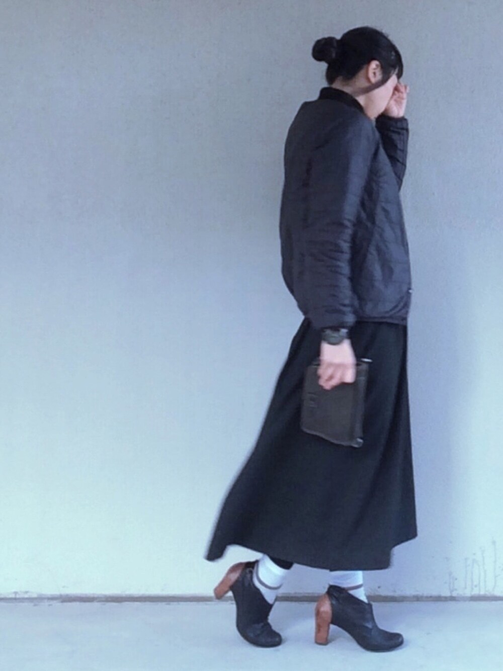 ブラック系のニット/セーター、ブラック系のショルダーバッグ、ブラック系のダウンジャケット/コートを着用したレディースの冬コーディネートの1枚目の写真