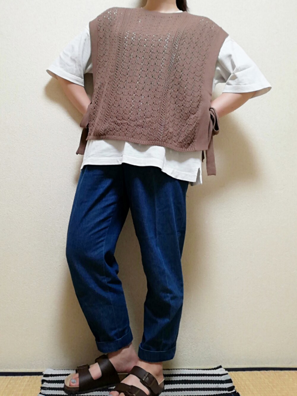 ブラウン系のベスト、ホワイト系のTシャツ/カットソー、ブルー系のデニムパンツを着用したレディースの夏コーディネートの1枚目の写真