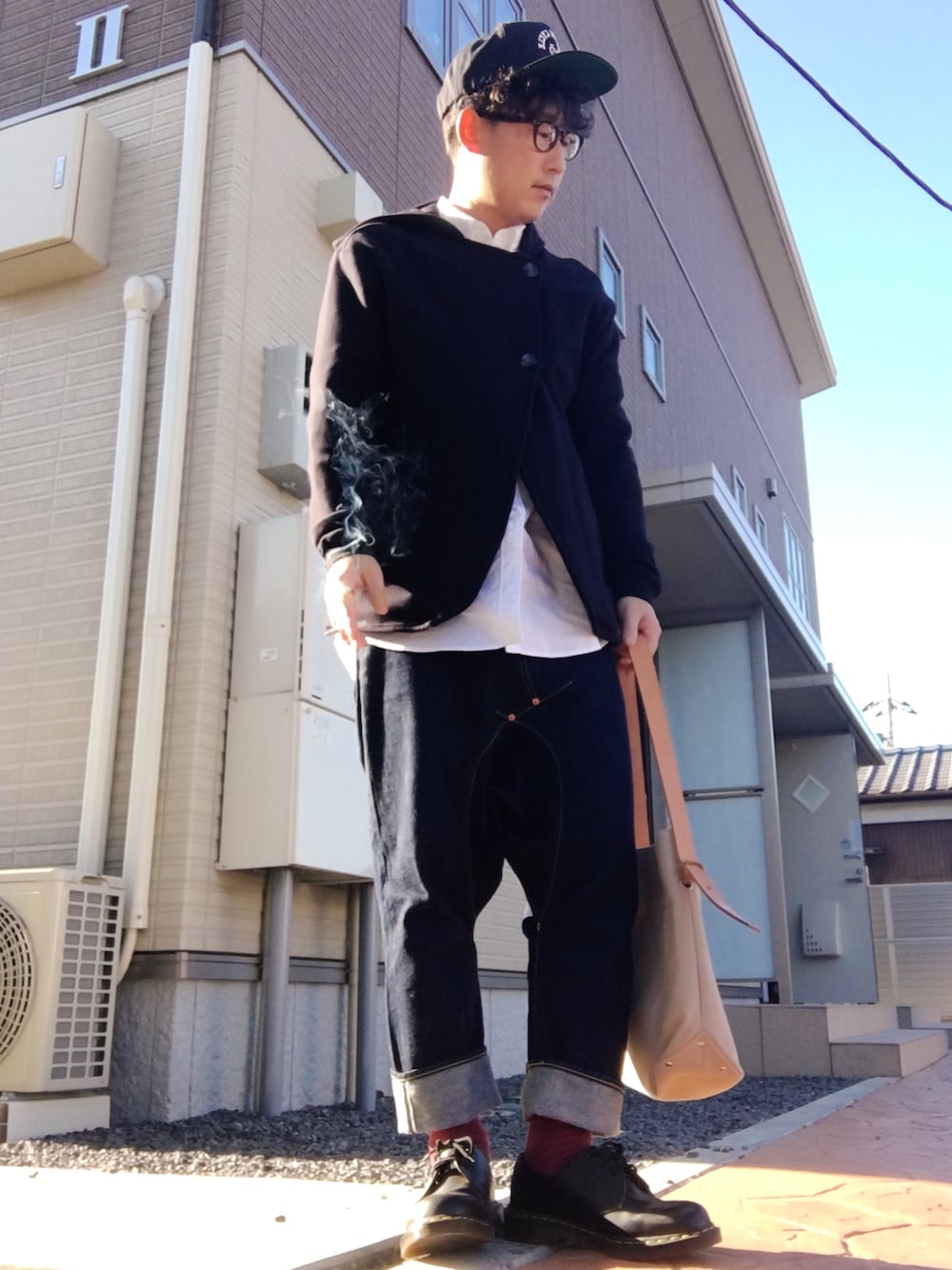 ブルー系のパーカー、ブルー系のデニムパンツ、ブラック系のブーツを着用したメンズの冬コーディネートの1枚目の写真