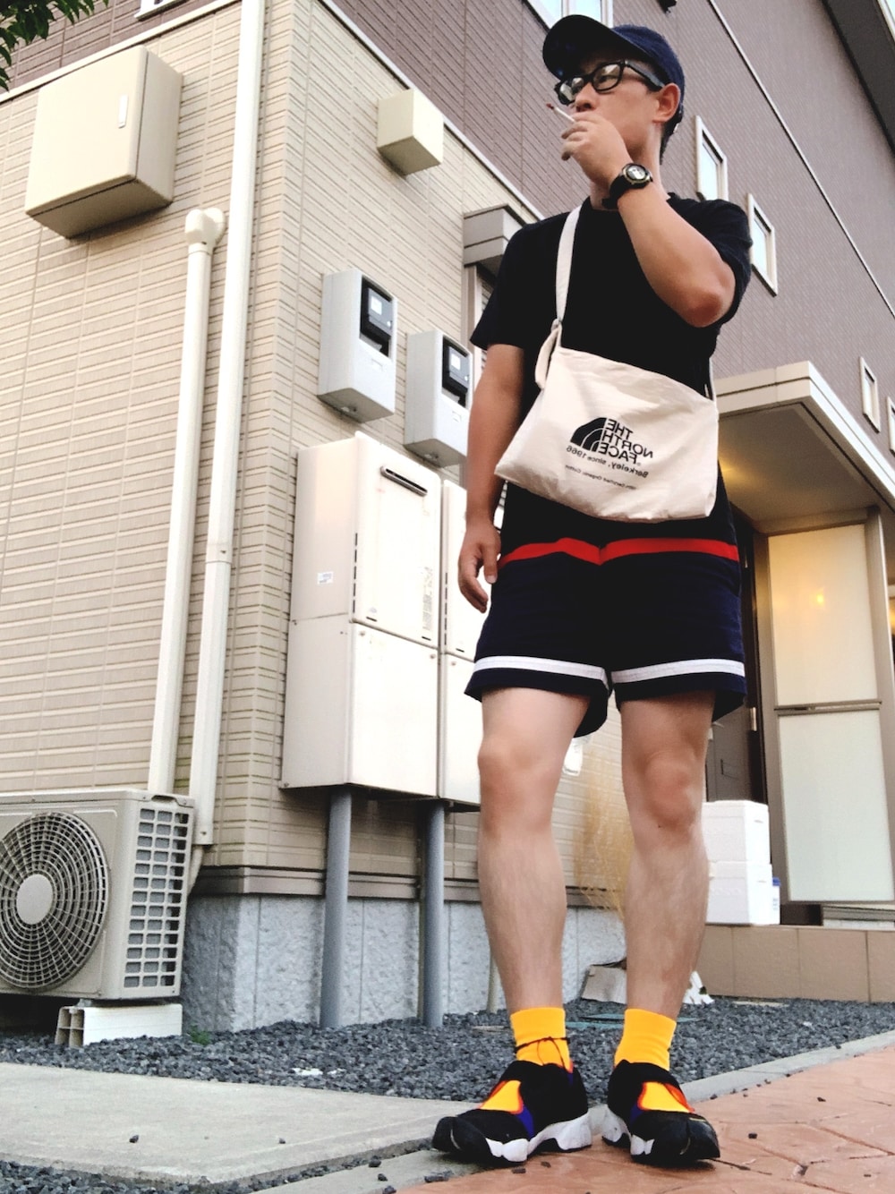 ブラック系のスニーカー、ホワイト系のTシャツ/カットソー、ブルー系のその他パンツを着用したメンズの秋コーディネートの1枚目の写真