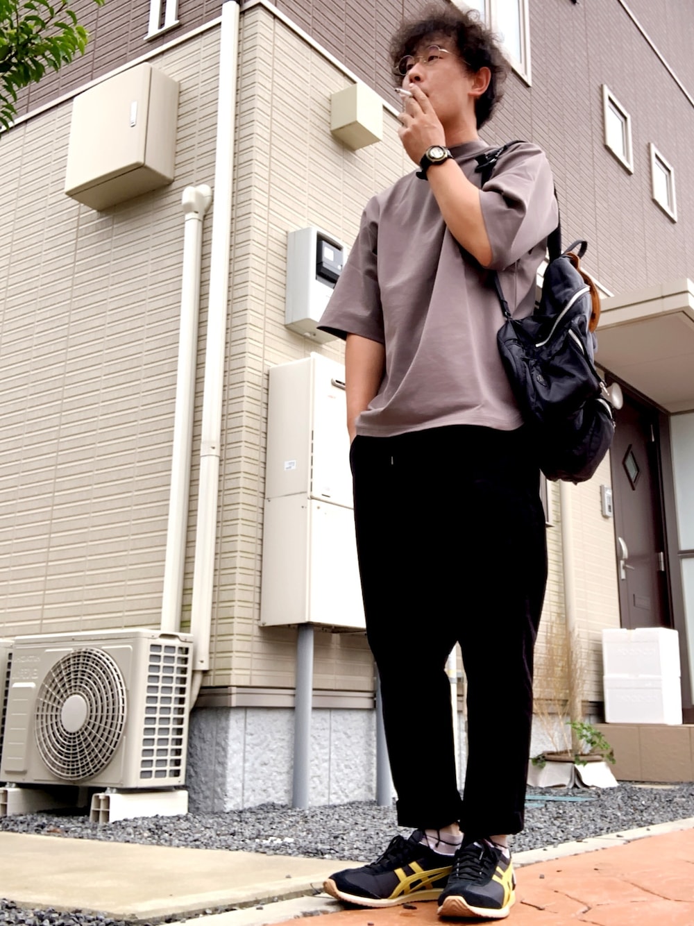 ブラウン系のTシャツ/カットソー、ブラック系のバックパック/リュック、ブラック系のスニーカーを着用したメンズの秋コーディネートの1枚目の写真