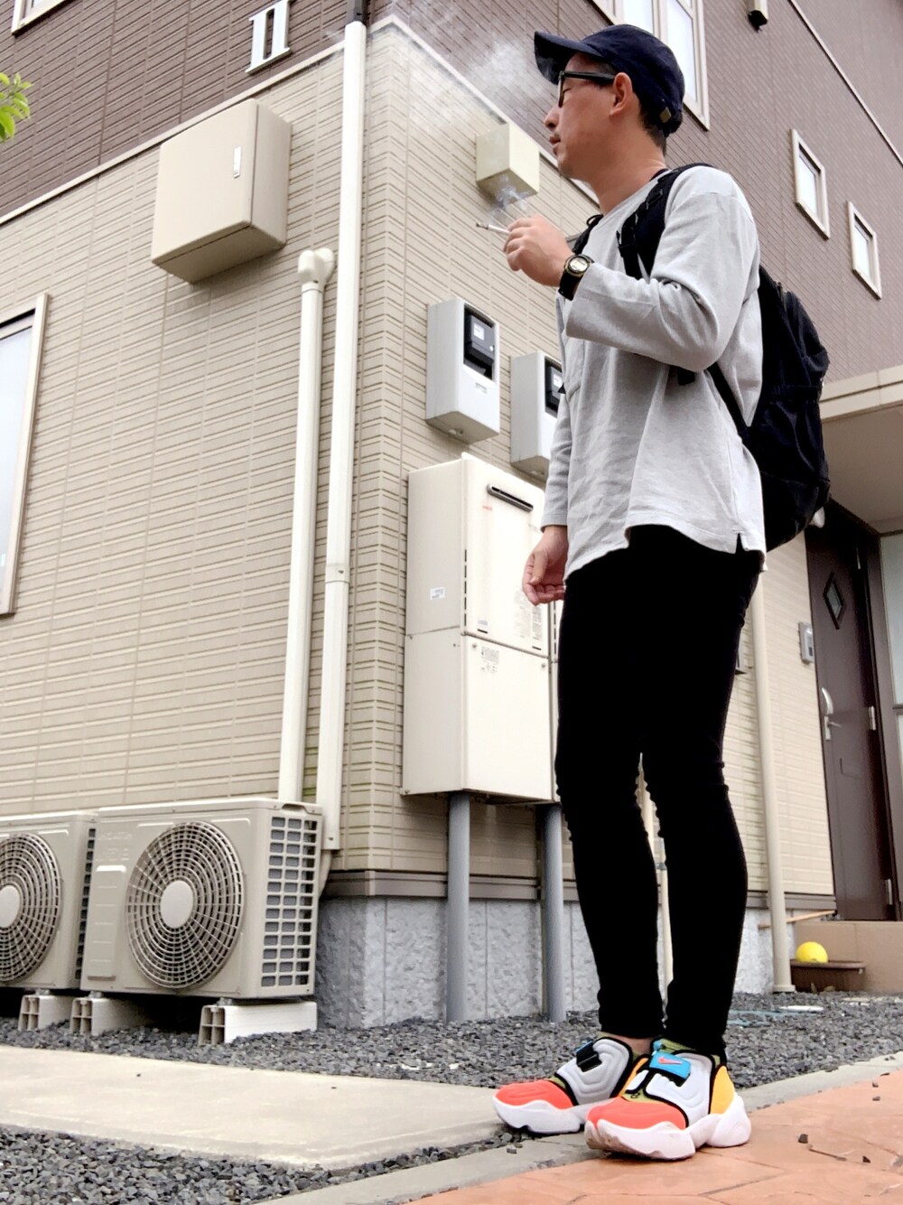 ブラック系のスラックス、その他のスニーカー、グレー系のTシャツ/カットソーを着用したメンズの春コーディネートの1枚目の写真