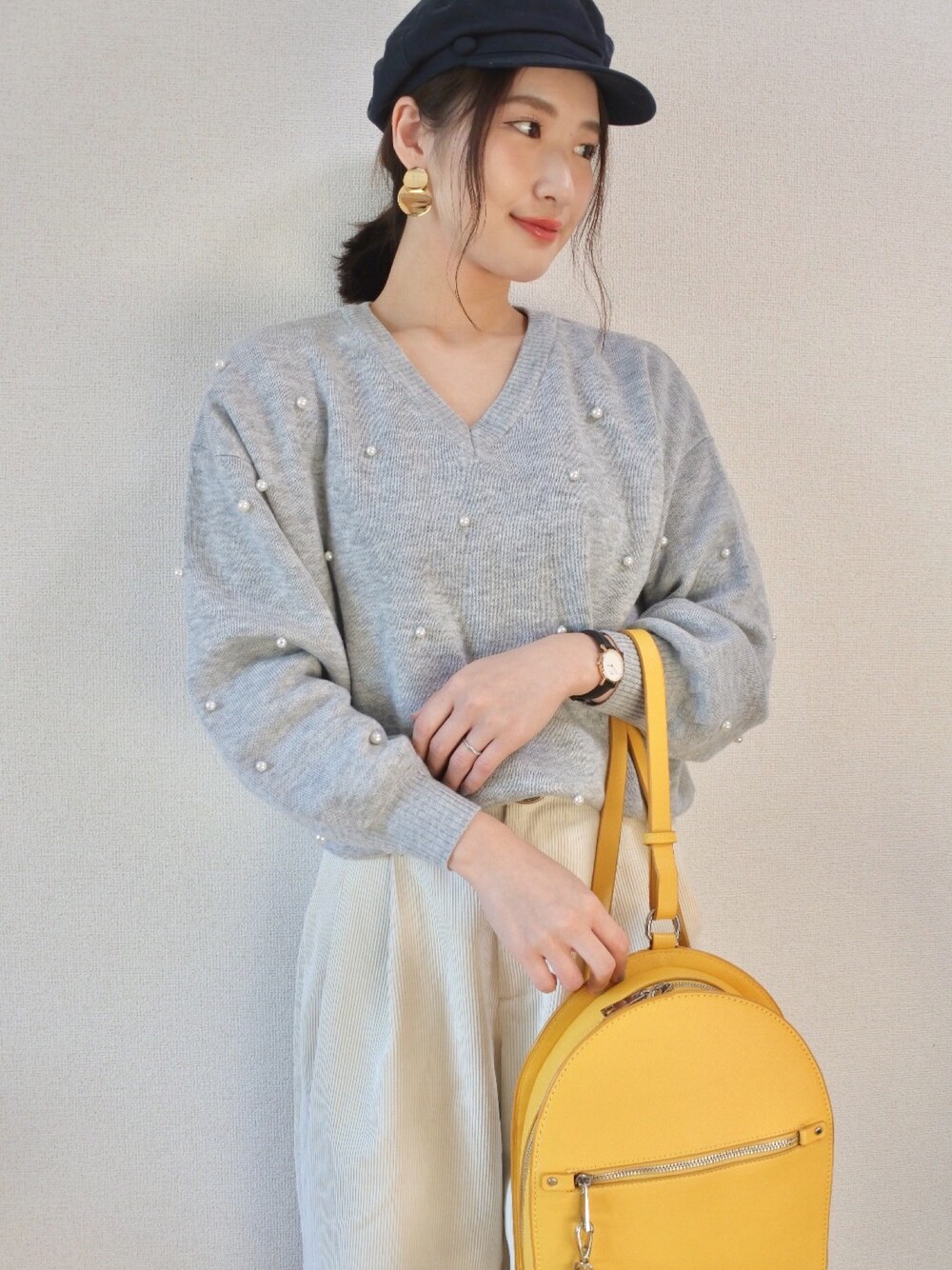ホワイト系のその他パンツ、イエロー系のバックパック/リュック、パープル系のニット/セーターを着用したレディースの冬コーディネートの1枚目の写真