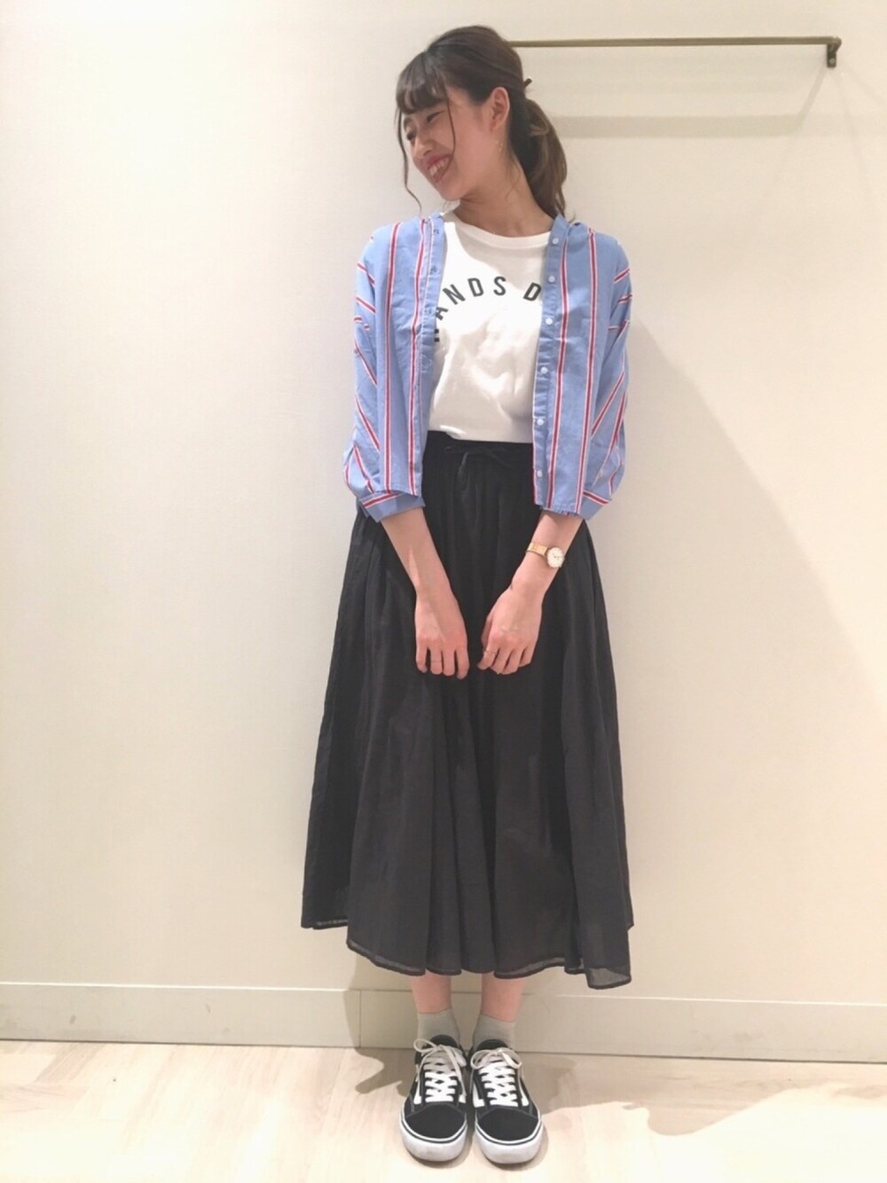 ブラック系のスカート、レッド系のトップス、ホワイト系のTシャツ/カットソーを着用したレディースの春コーディネートの1枚目の写真