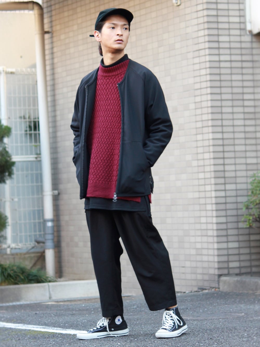 レッド系のニット/セーター、ブラック系のTシャツ/カットソー、ブラック系のその他パンツを着用したメンズの冬コーディネートの1枚目の写真