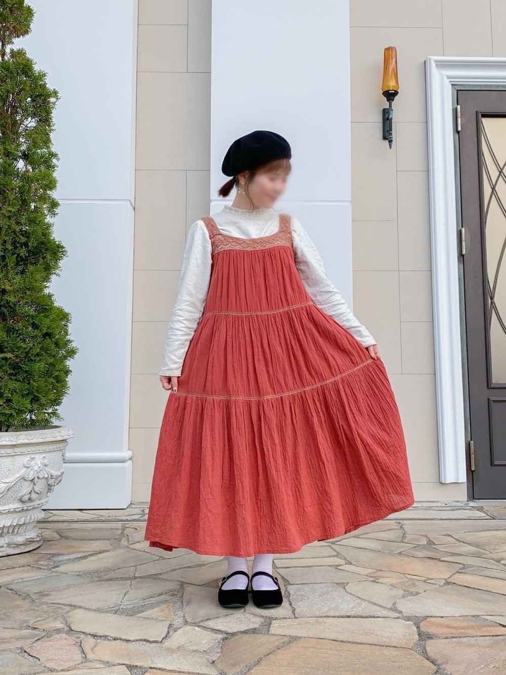 オレンジ系のワンピース/ドレス、ベージュ系のトップス、ブラック系のバレエシューズを着用したレディースの冬コーディネートの1枚目の写真