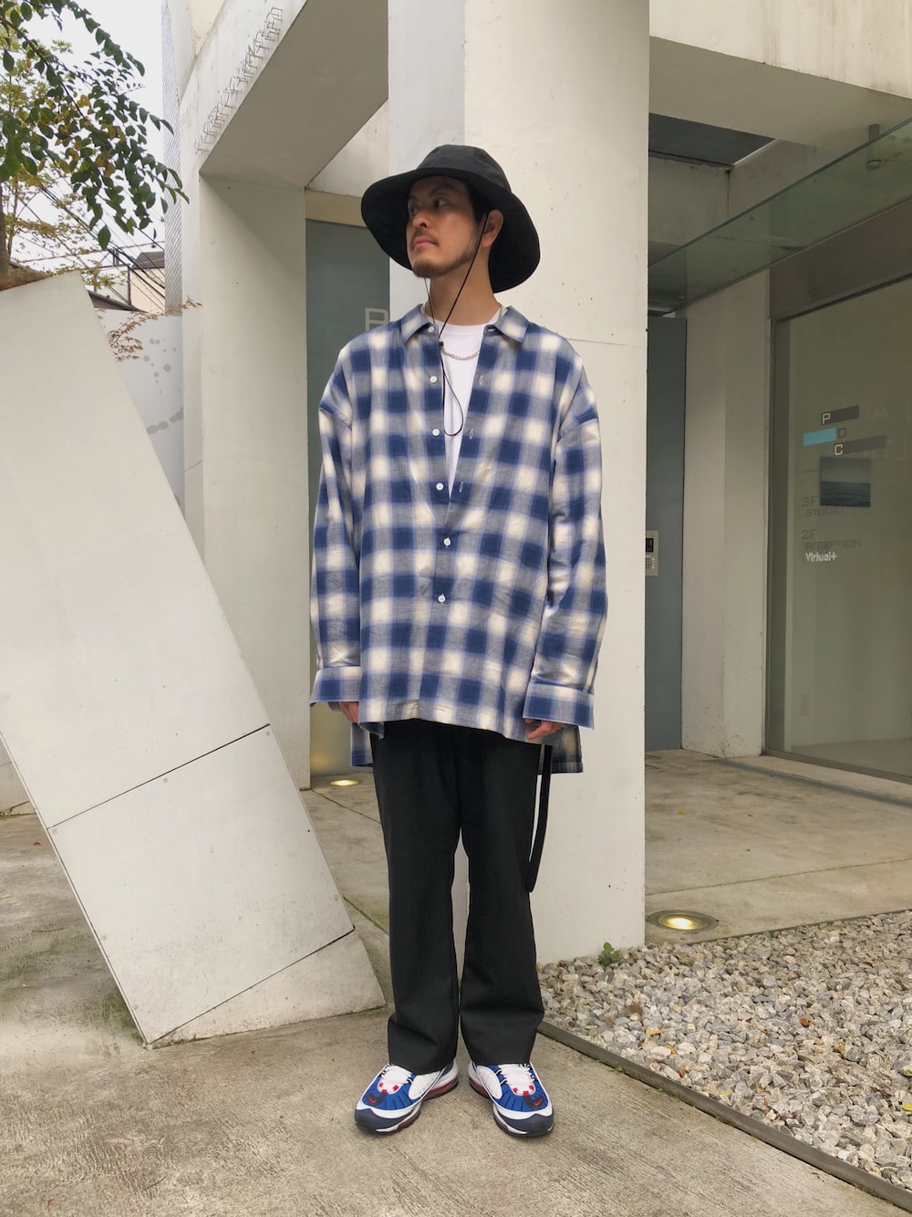 ブルー系のシャツ/ブラウス、ブラック系のパンツ、ブルー系のスニーカーを着用したメンズの春コーディネートの1枚目の写真