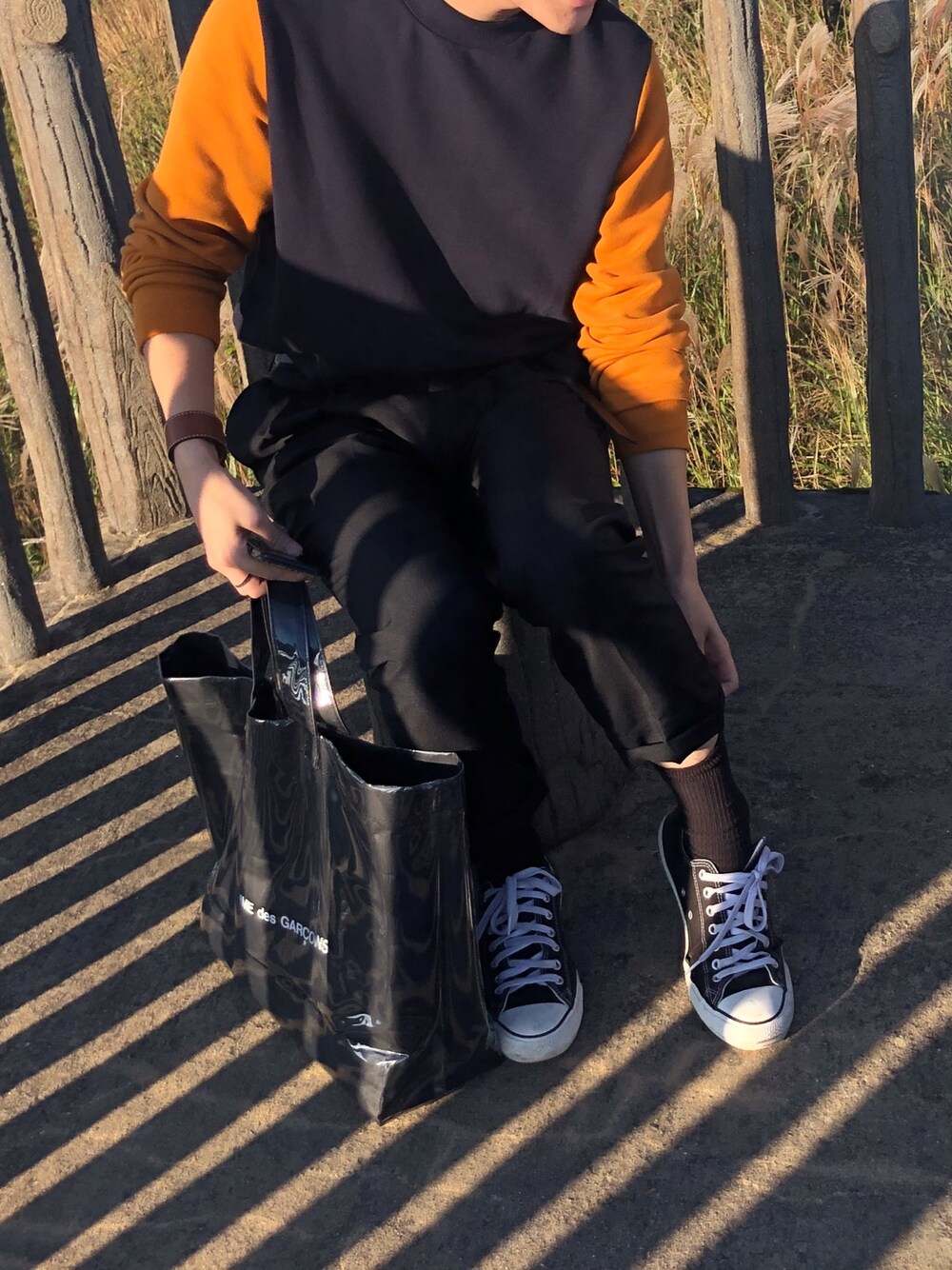 ブラック系のTシャツ/カットソー、ブラック系のトートバッグ、ブラック系のスラックスを着用したメンズの秋コーディネートの1枚目の写真