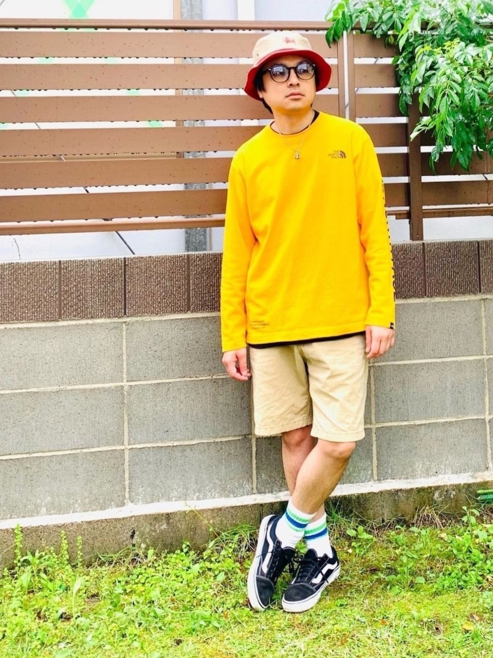 イエロー系のTシャツ/カットソー、ベージュ系のその他パンツ、ブラック系のスニーカーを着用したメンズの春コーディネートの1枚目の写真