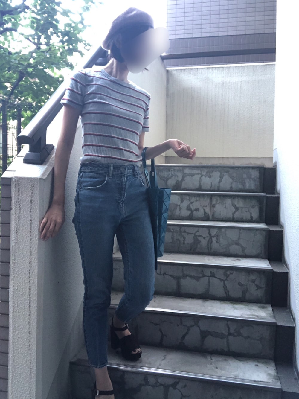 ブルー系のトートバッグ、ブラウン系のサンダル、ブルー系のデニムパンツを着用したレディースの夏コーディネートの1枚目の写真