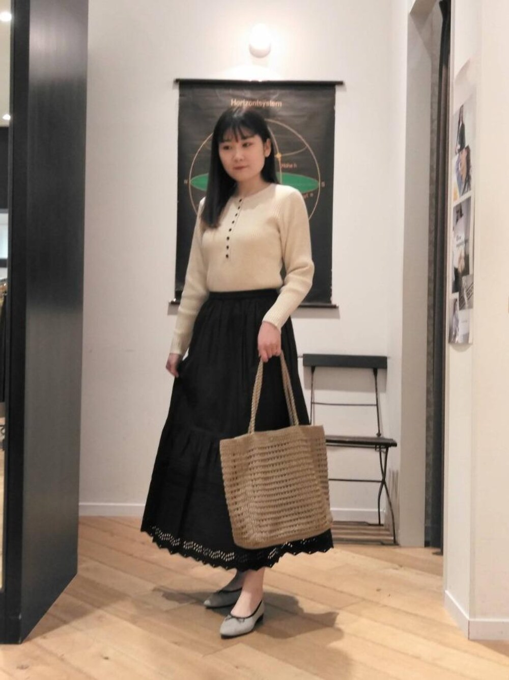 ベージュ系のトートバッグ、ベージュ系のバレエシューズ、ブラック系のスカートを着用したレディースの冬コーディネートの1枚目の写真