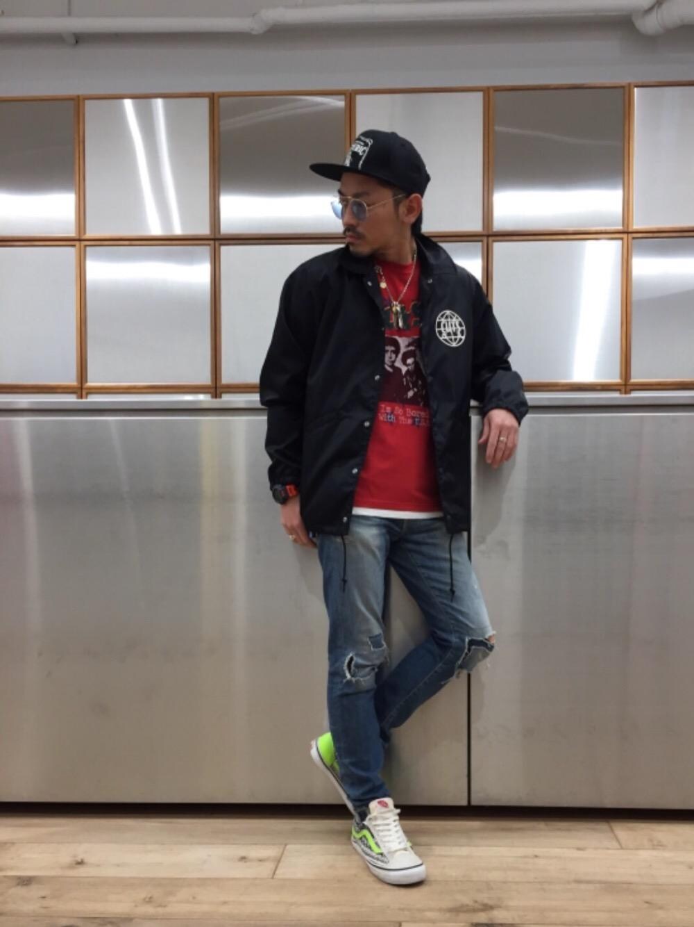 ブルー系のデニムパンツ、ブラック系のブルゾン、レッド系のTシャツ/カットソーを着用したメンズの春コーディネートの1枚目の写真