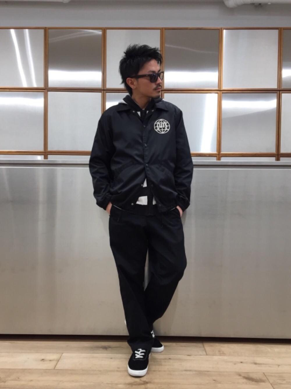 ブラック系のチノパンツ、ブラック系のブルゾン、ブラック系のパーカーを着用したメンズの春コーディネートの1枚目の写真