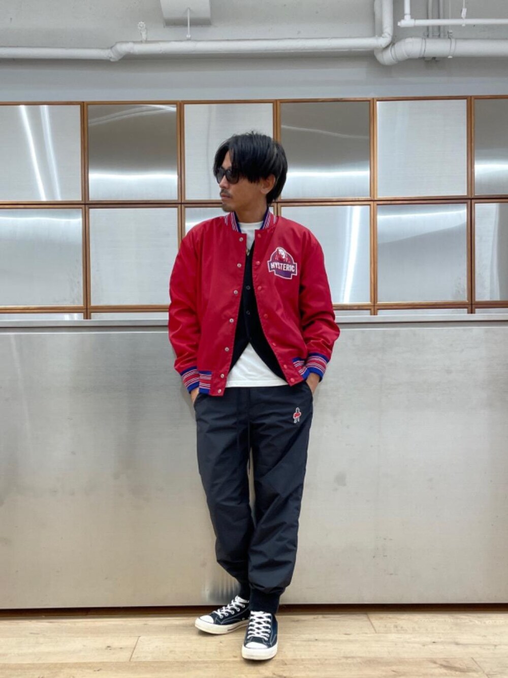 ブラック系のスニーカー、ホワイト系のTシャツ/カットソー、レッド系のブルゾンを着用したメンズの秋コーディネートの1枚目の写真