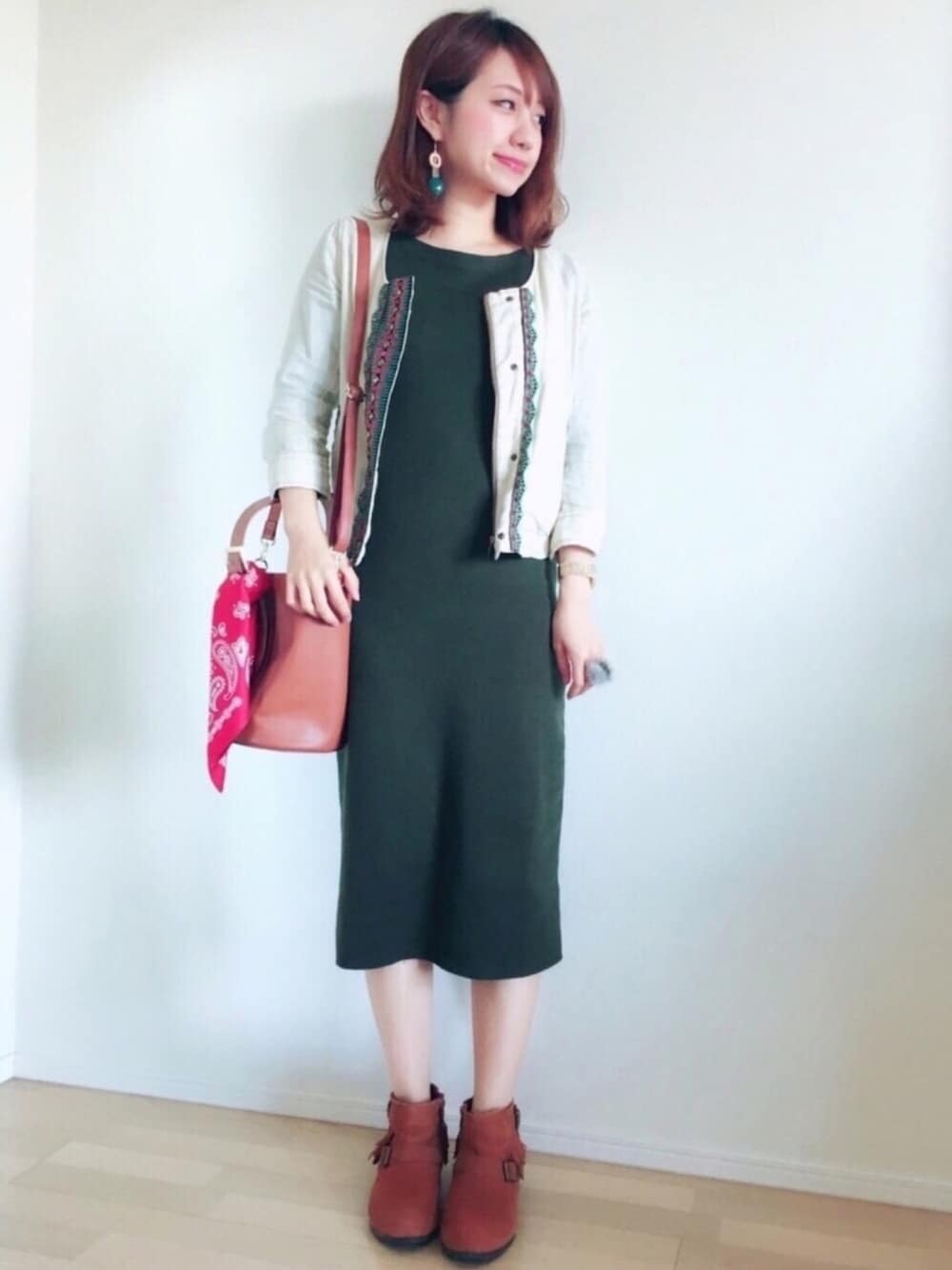 グリーン系のワンピース、ブラウン系のブーツ、ブラウン系のバッグを着用したレディースの春コーディネートの1枚目の写真