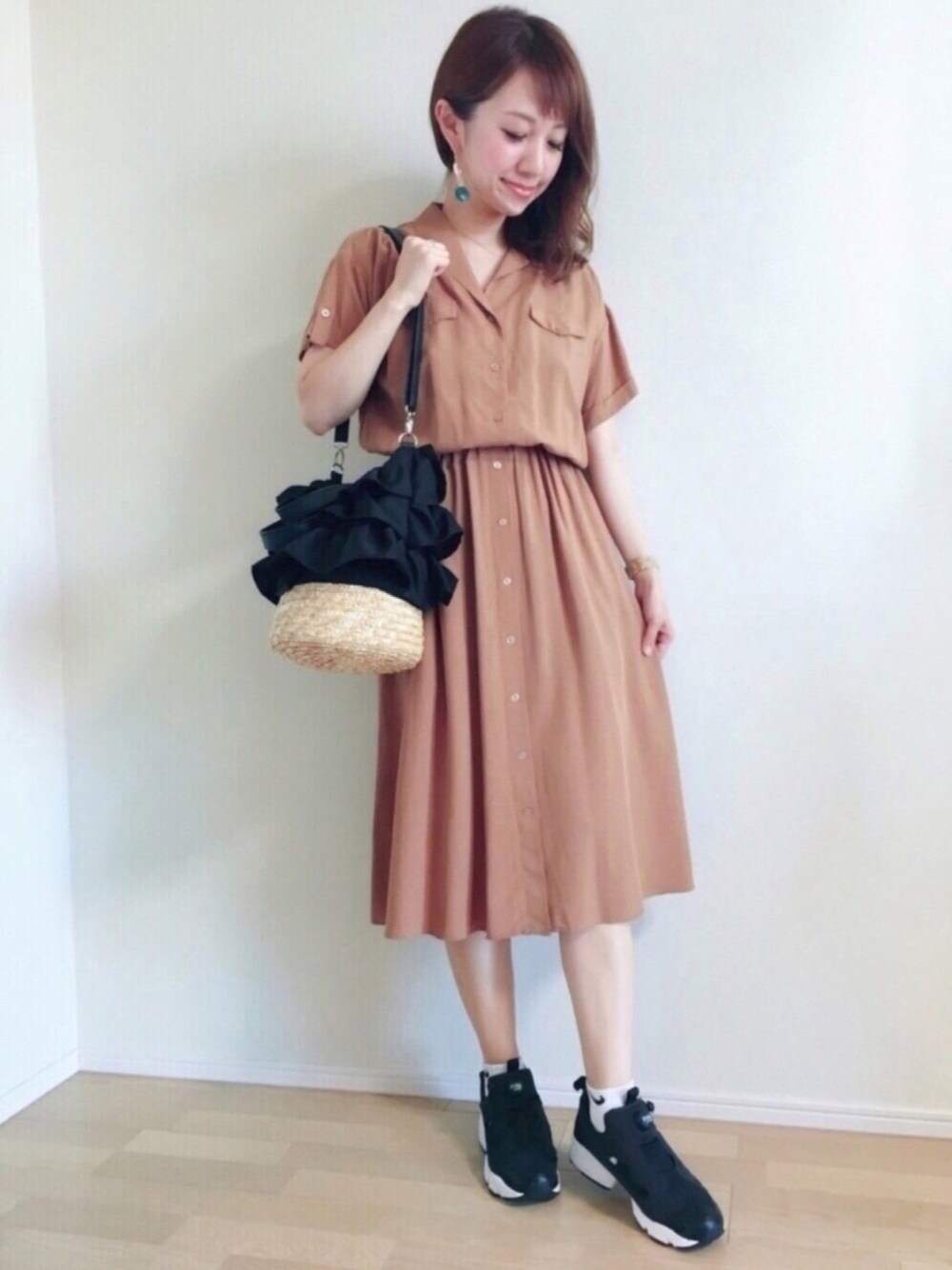 ブラック系のスニーカー、ブラウン系のワンピース、ホワイト系のソックス/靴下を着用したレディースの春コーディネートの1枚目の写真