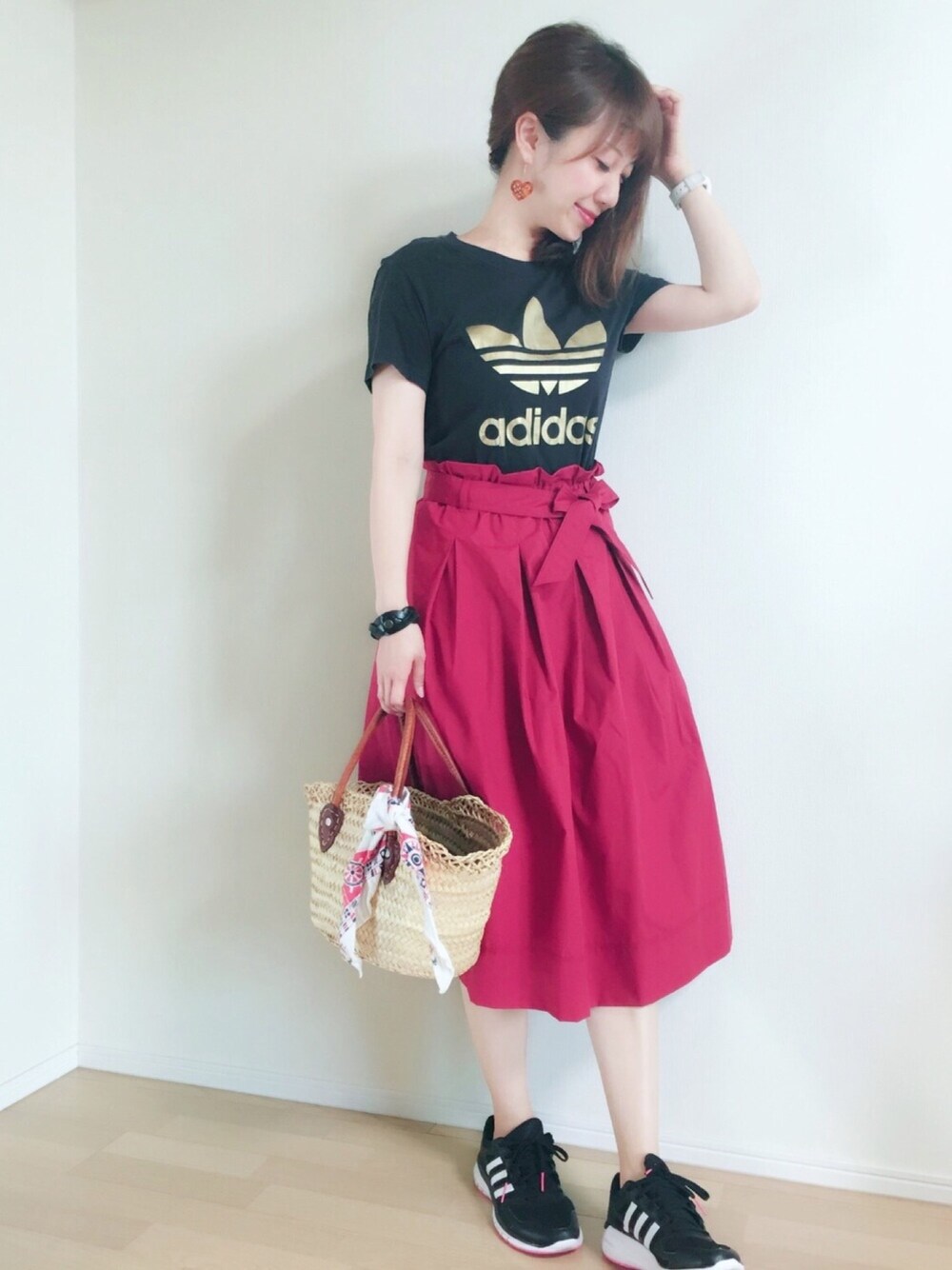 ブラック系のTシャツ/カットソー、レッド系のスカート、ブラック系のスニーカーを着用したレディースの夏コーディネートの1枚目の写真