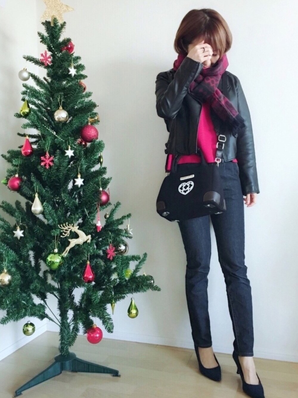 レッド系のニット/セーター、ブルー系のデニムパンツ、ブルー系のパンプスを着用したレディースの冬コーディネートの1枚目の写真