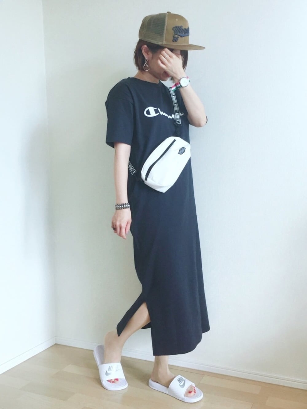 ブルー系のワンピース、ホワイト系のサンダル、ベージュ系のキャップを着用したレディースの夏コーディネートの1枚目の写真